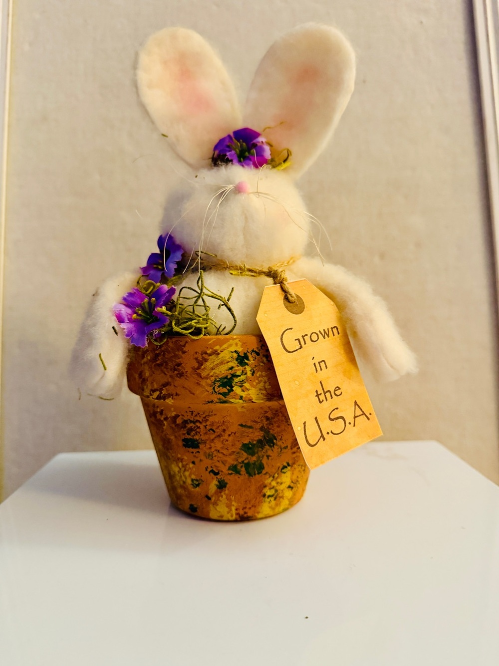 handmade vintage Easter bunny figurine nested inside a decorated clay pot